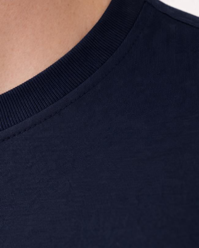 Nahaufnahme des weichen Rundhalsausschnitts eines Tencel-Shirts; hypoallergene und atmungsaktive Materialeigenschaften ideal für sensible Haut.