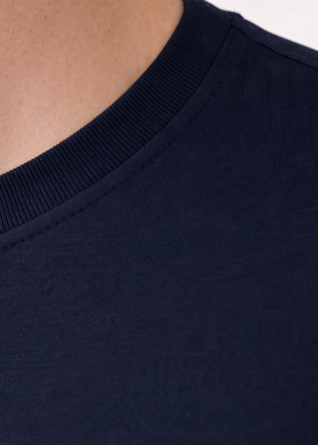 Nahaufnahme des weichen Rundhalsausschnitts eines Tencel-Shirts; hypoallergene und atmungsaktive Materialeigenschaften ideal für sensible Haut.