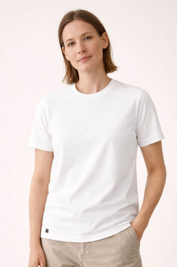 Frau präsentiert weißes BREDDY’S TEE CORE – schlicht, modern und nachhaltig.
