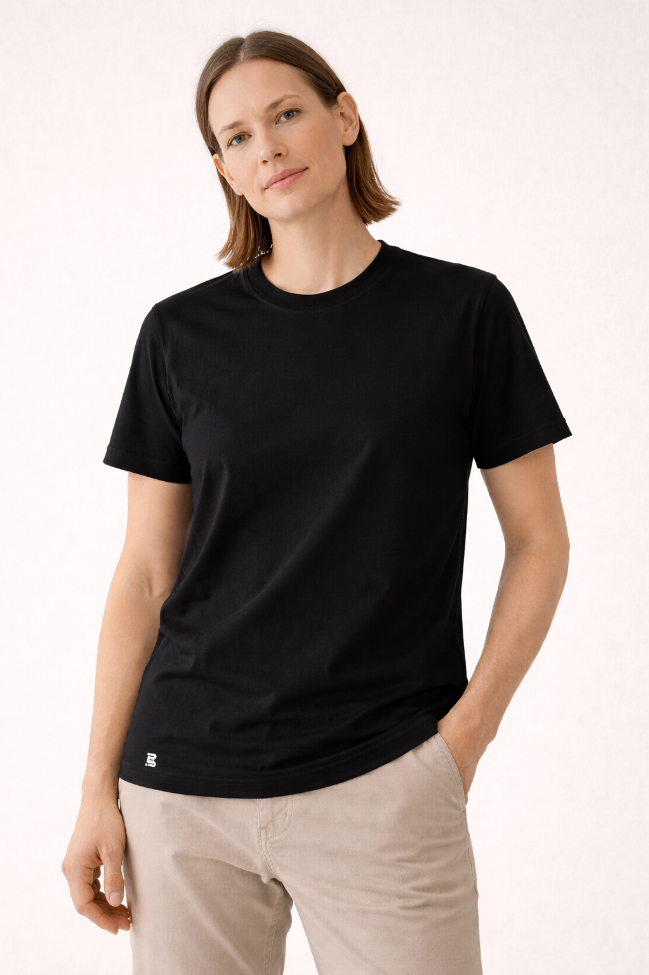 Frau trägt schwarzes BREDDY’S TENCEL™ T-Shirt im minimalistischen Studiofoto.
