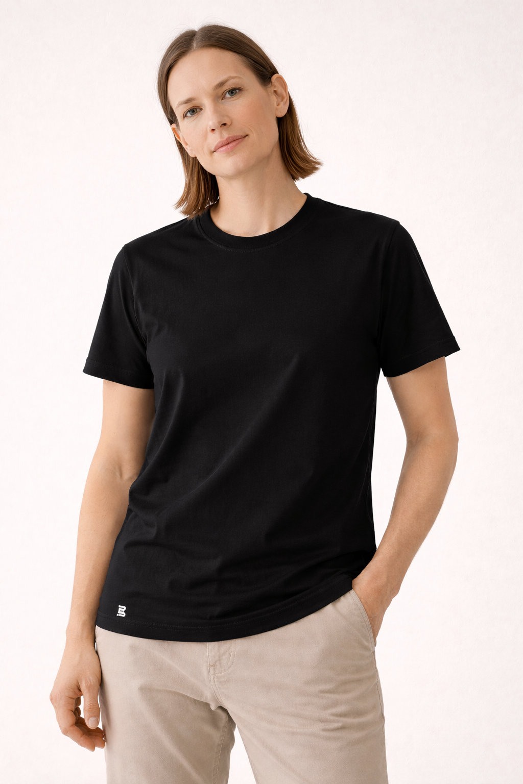 Frau trägt schwarzes BREDDY’S TENCEL™ T-Shirt im minimalistischen Studiofoto.