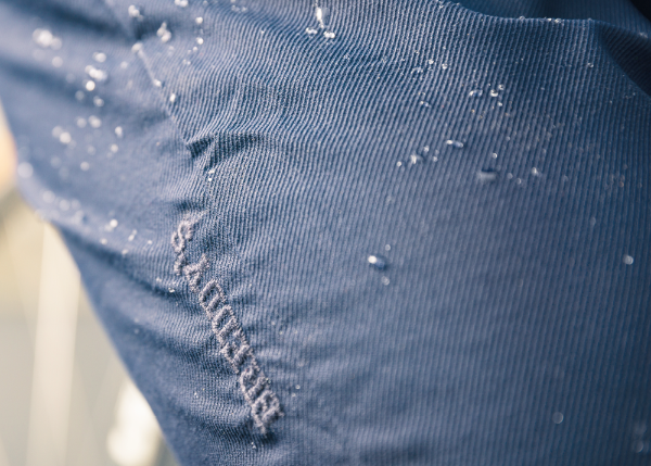 Wasser perlt von blauer Breddys Hose ab. Gerillte Struktur der Hose ist gut sichtbar.