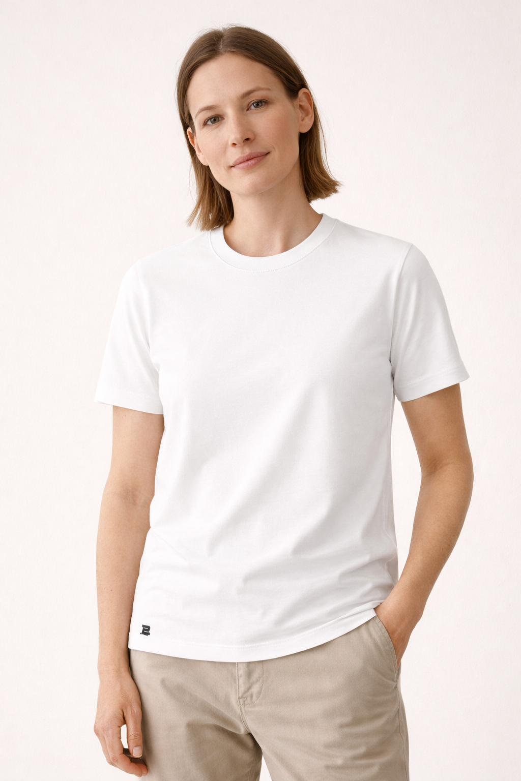 Frau präsentiert weißes BREDDY’S TEE CORE – schlicht, modern und nachhaltig.