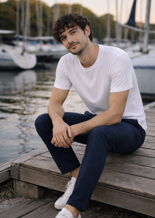 Mann sitzt entspannt am Steg und trägt BREDDY’S Pants mit TENCEL™ T-Shirt